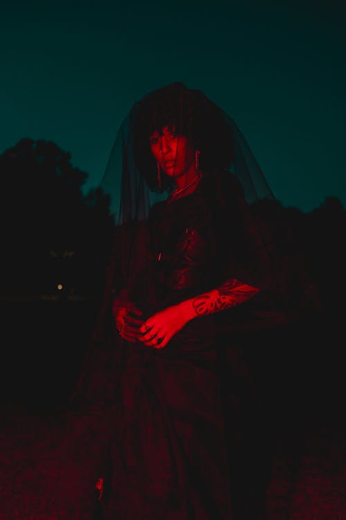 Woman in a Black Veil Posing Outside in the Dark 