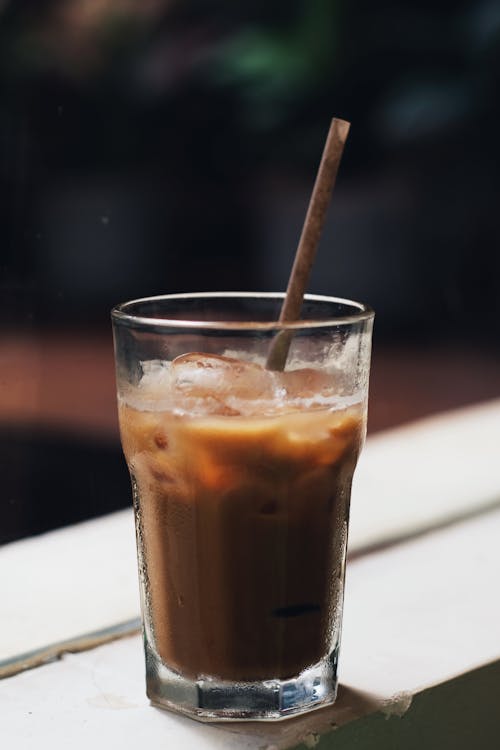  A Glass with Iced Coffee and a Paper Straw 