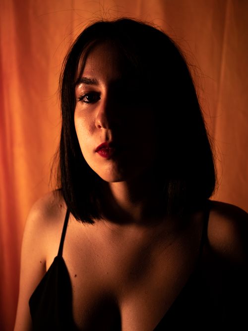 Free Dramatic portrait of a woman with shadowed lighting and bold expression. Stock Photo
