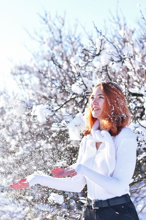Free Smiling young woman in the snow, surrounded by frosty trees, enjoying winter's beauty. Stock Photo