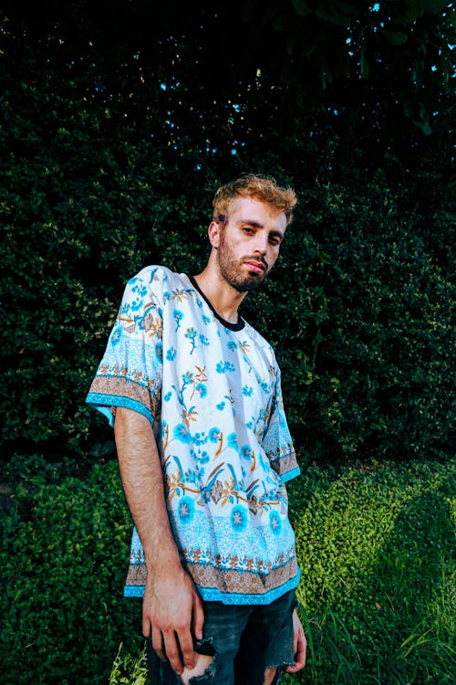 Young Man in a Patterned T-shirt Posing Outside 