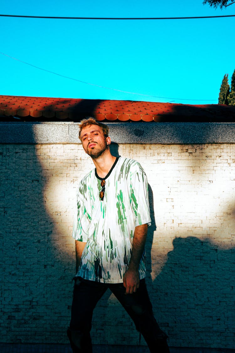 Young Man Standing Outside In Sunlight 