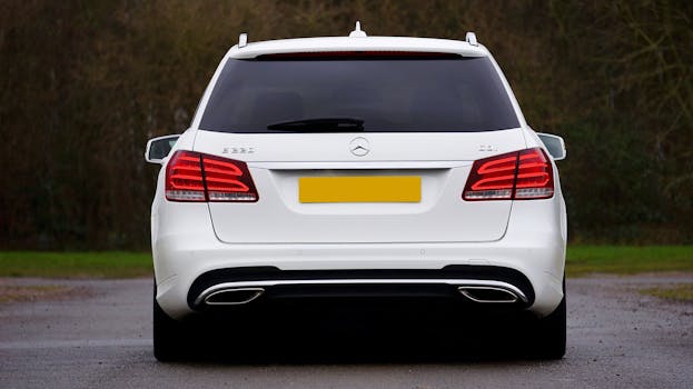 Rear view of a white Mercedes E-Class parked outdoors on an empty road.