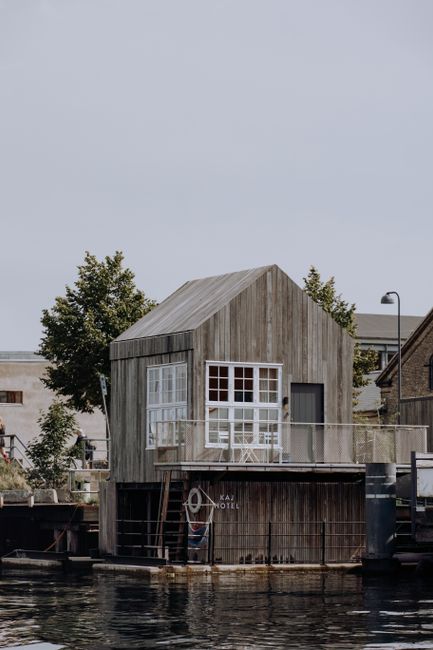Discover the charming Kaj Hotel, a wooden houseboat on a canal in Copenhagen, Denmark.