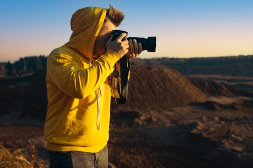 Man Taking a Picture in a Mountain Valley 