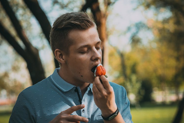 Man Eating A Strawberry With Cream 