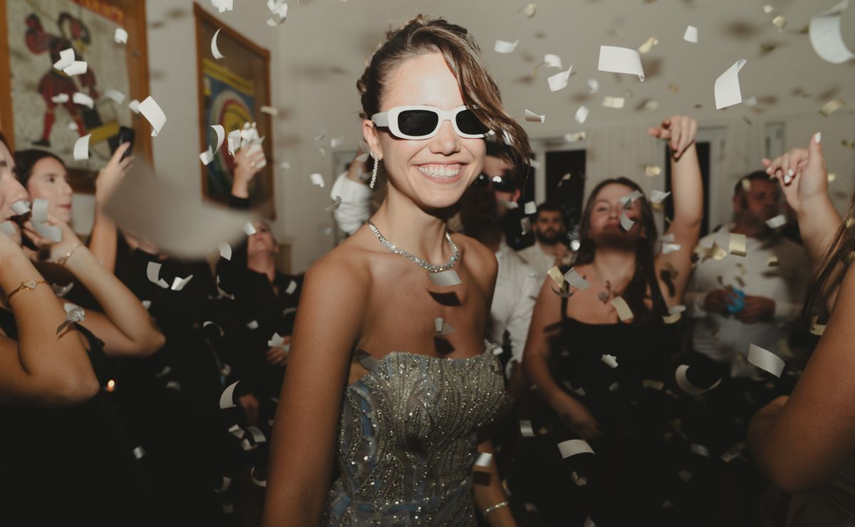 Two friends laughing under a shower of colourful confetti at a Snapwhirl photo booth