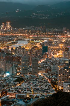 Stunning aerial shot of a cityscape illuminated at night, showcasing skyscrapers and vibrant urban life.