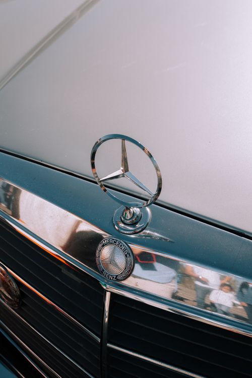 Free Detailed view of the iconic Mercedes-Benz emblem on a car's front grille. Stock Photo