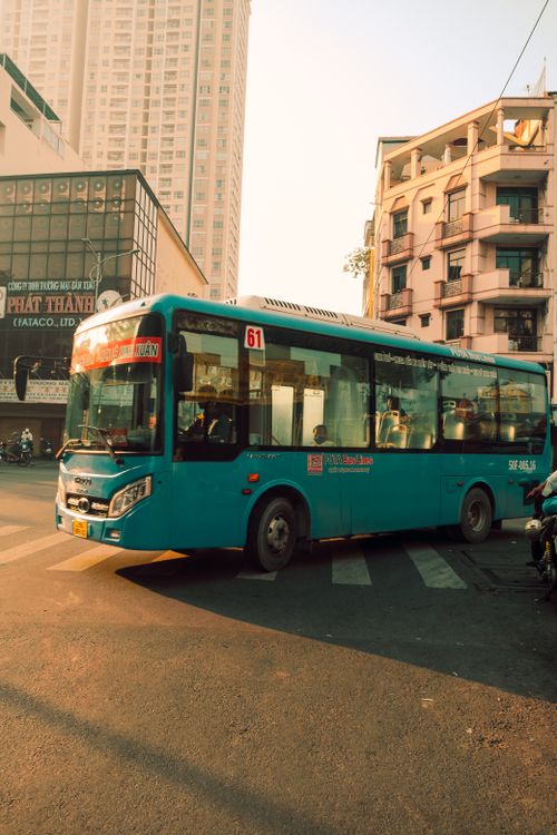 Free A blue urban bus maneuvering through city streets during the day. Stock Photo