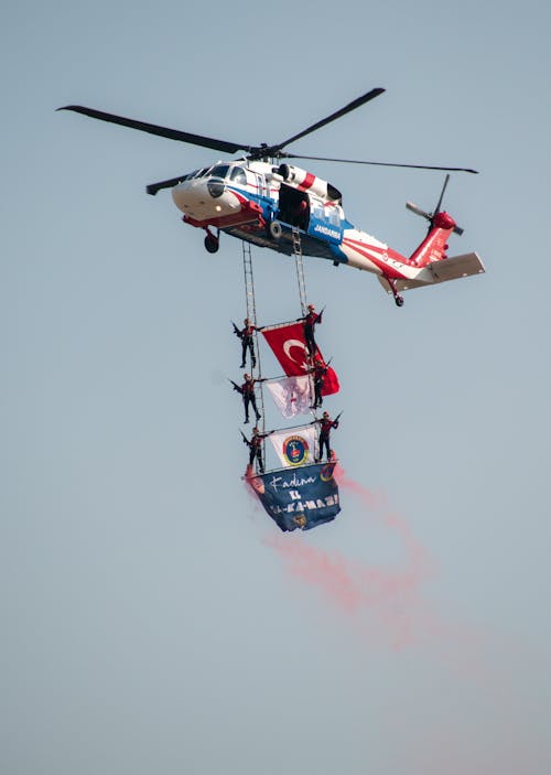 Soldiers with Flags under Flying Helicopter