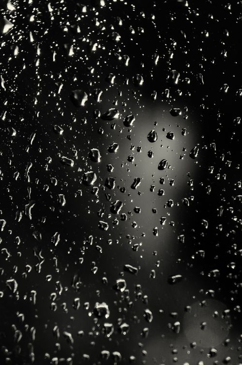 Free Close-up macro view of raindrops on a glass window with blurred background. Stock Photo