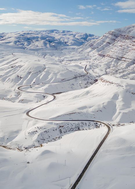 Stunning aerial view of a winding snow-covered road through Kemah, Erzincan, Türkiye.