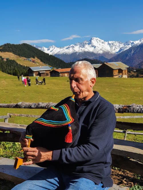 Elderly Man in Village Playing Traditional Musical Instrument