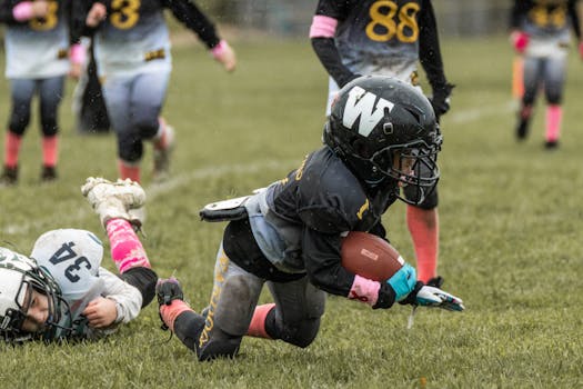 Youth players in intense American football game, showcasing determination and teamwork.