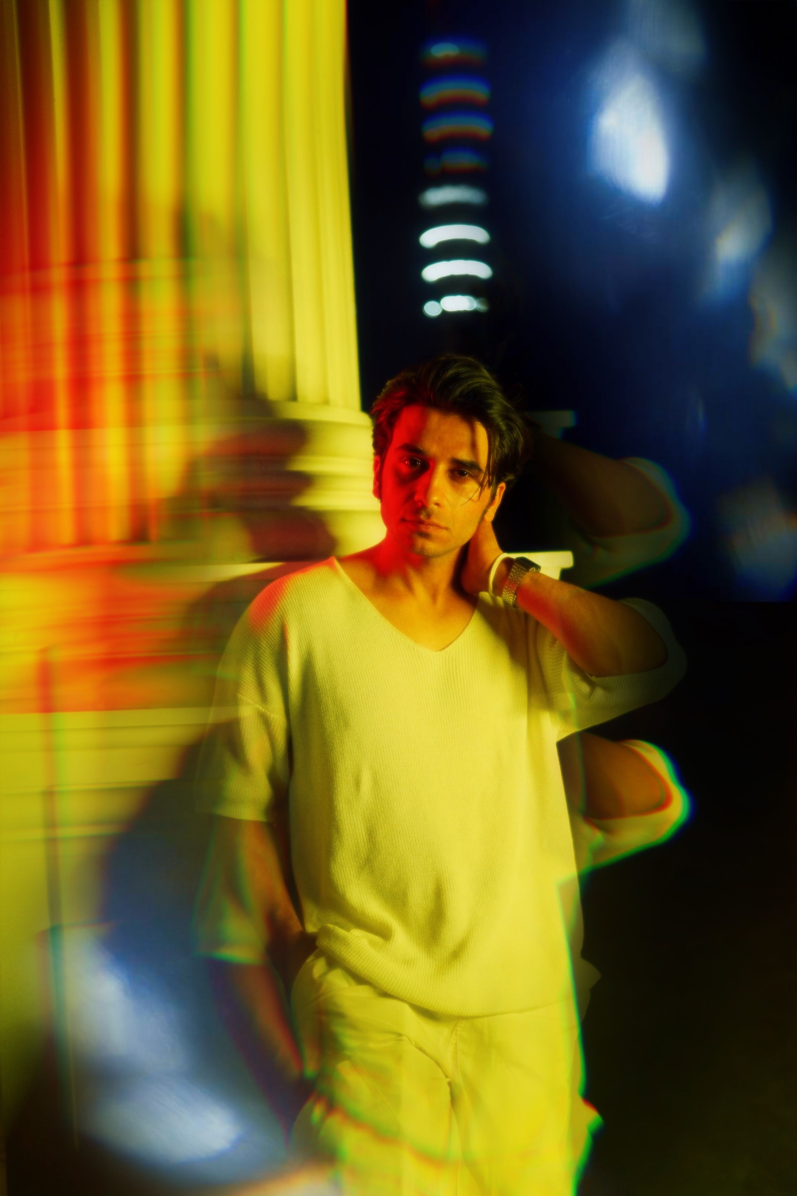 Creative night portrait of a man in motion with vibrant lights and blurred effects.
