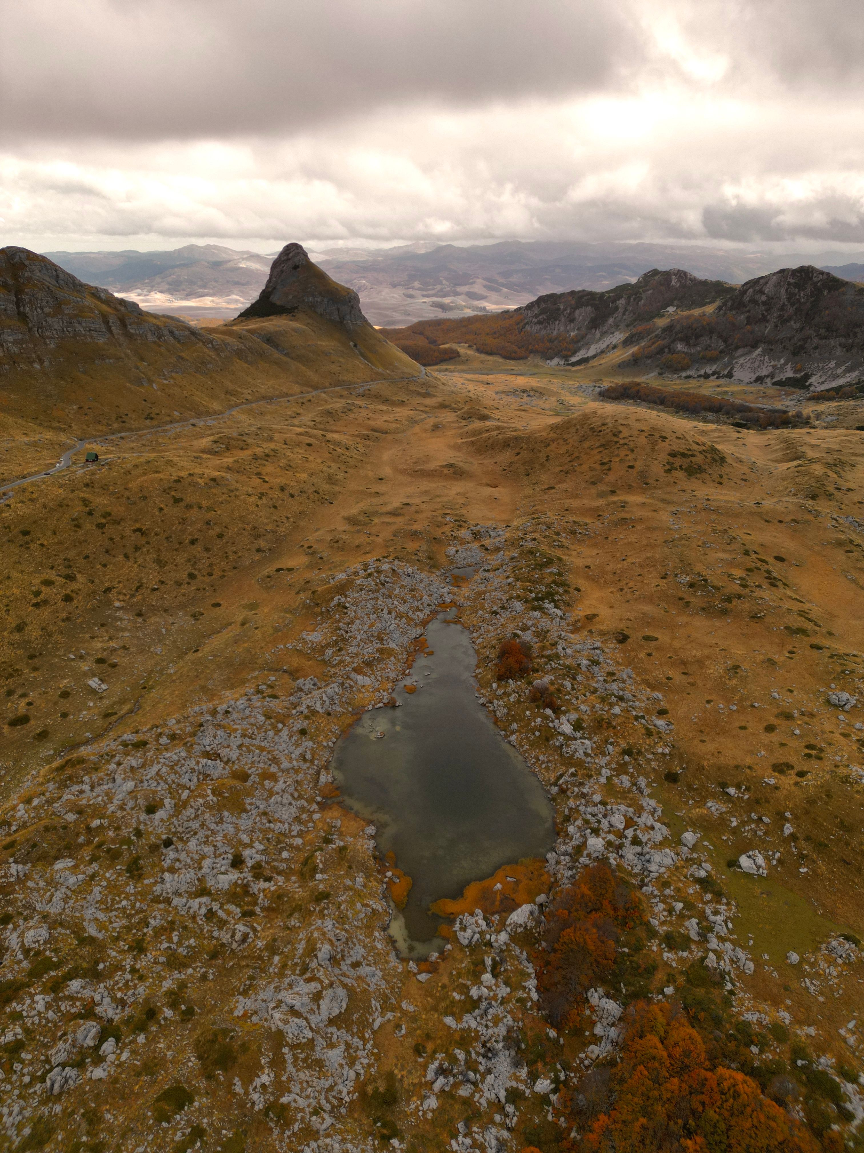 A breathtaking aerial view of the rugged terrain and tranquil pond in Žabljak, Montenegro.