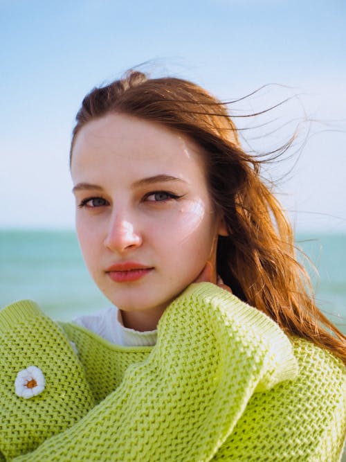 Pretty Young Woman in Lime Sweater by the Sea