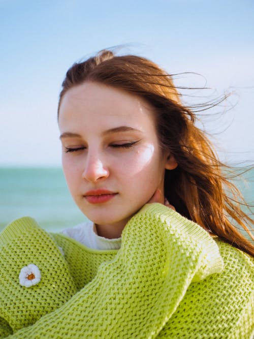 Young Woman in a Lime Sweater on the Beach