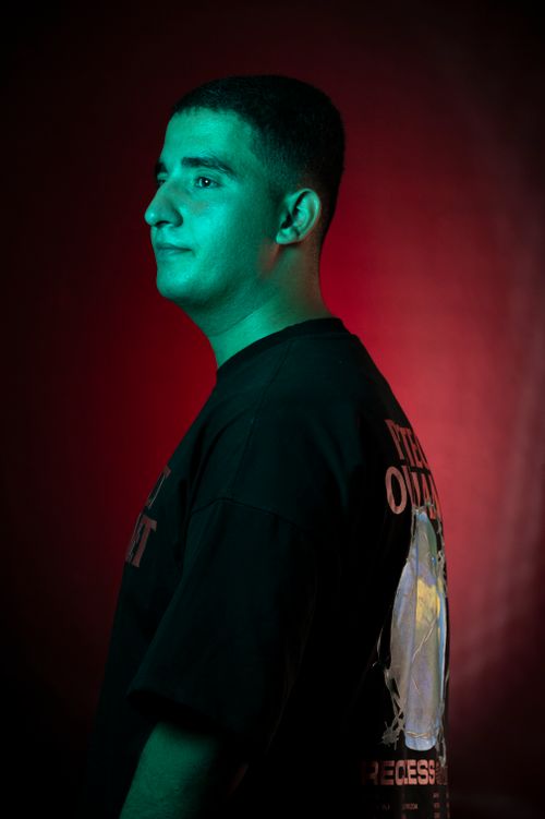Free Artistic portrait of a man in a black t-shirt with dynamic red and green lighting. Stock Photo