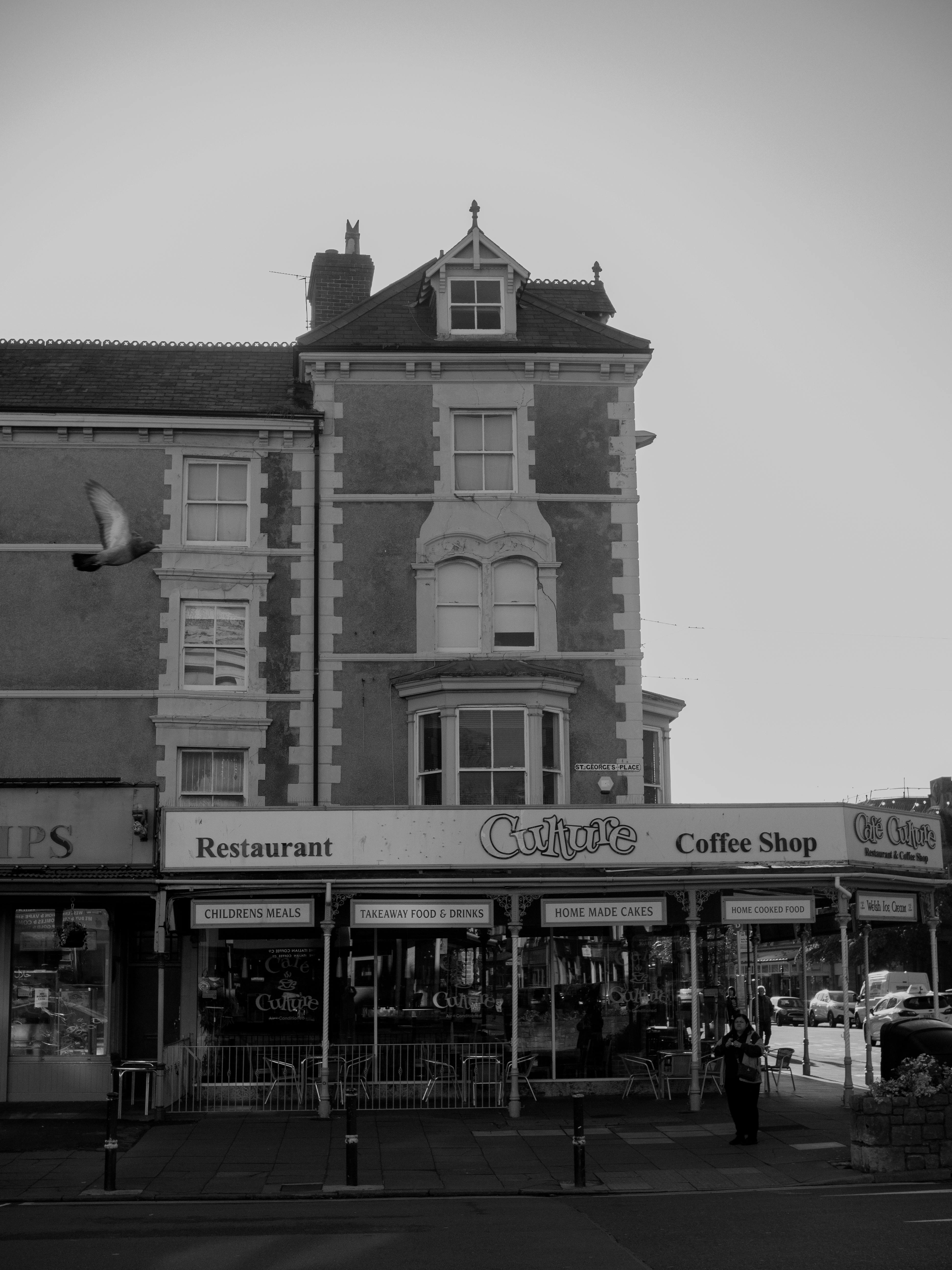 Black and white photo of a historic building housing a café and restaurant in Llandudno, UK.