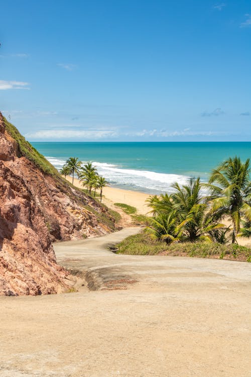 Foto profissional grátis de areia, céu azul, costa