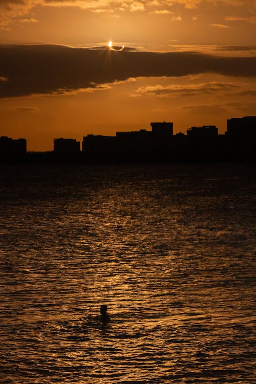 akşam karanlığı, altın gökyüzü, deniz içeren Ücretsiz stok fotoğraf