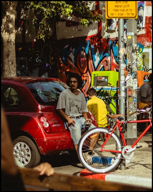 Základová fotografie zdarma na téma červené auto, držení, jízdní kolo