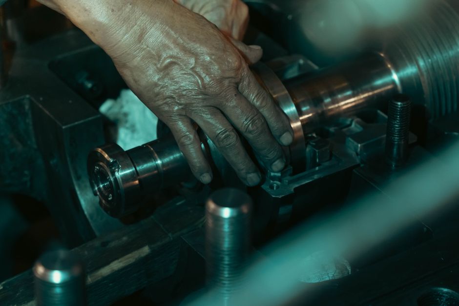 A machinist's hand adjusting a part on a metalworking machine — photo by abdo alshreef on Pexels
