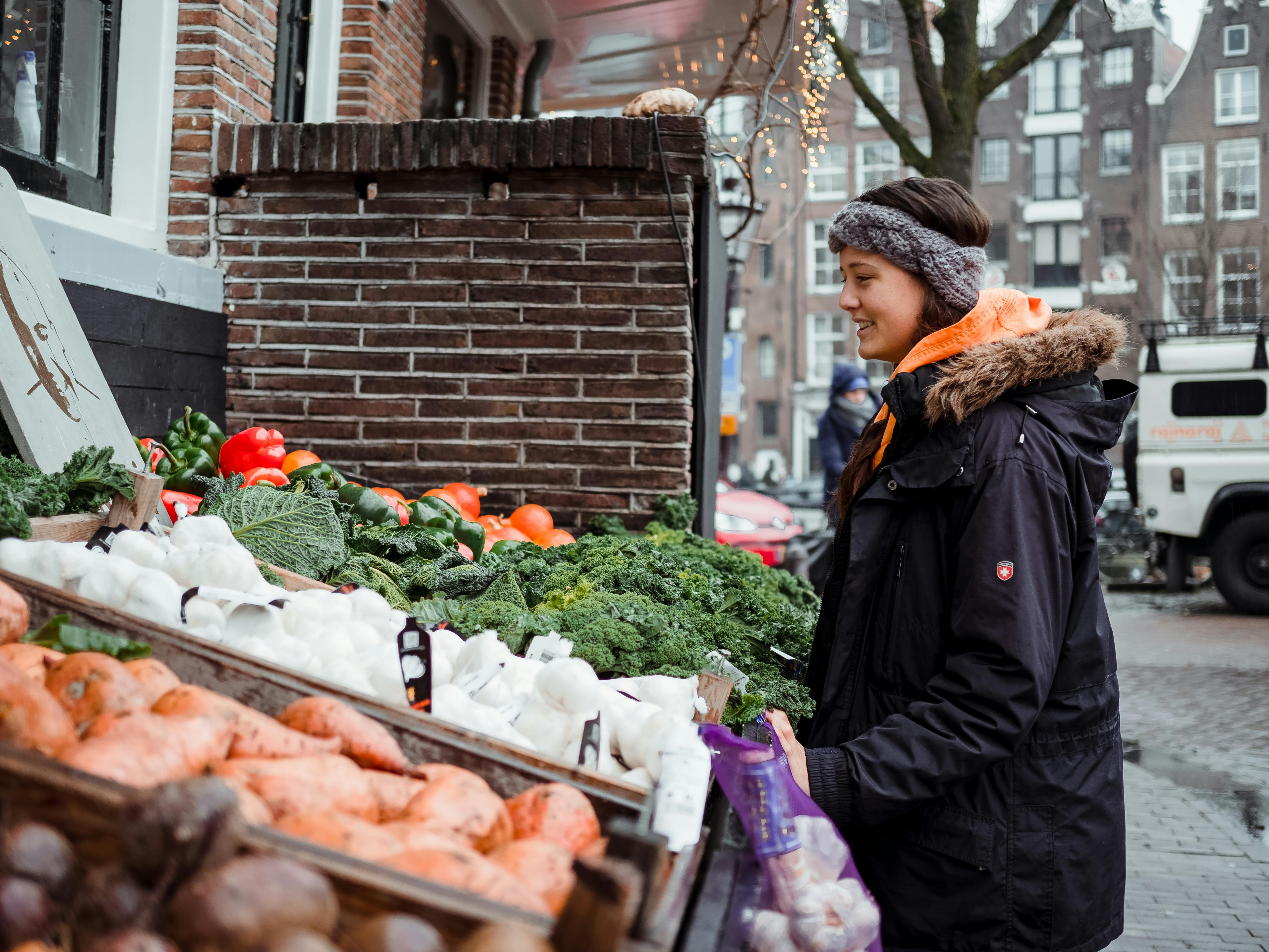 woman standing in front of vegetable stall