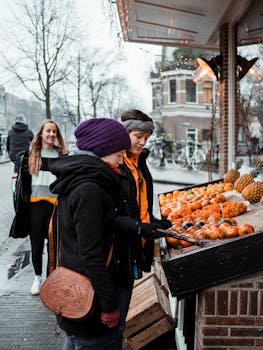 冬天，阿姆斯特丹的户外市场上，穿着保暖衣服的妇女们正在品尝新鲜水果