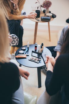 Women gathered around a table applying cosmetics, fostering a collaborative workspace.