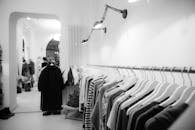 精品店的黑白时尚内饰，衣架上陈列着衣物，尽显现代风尚