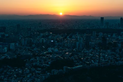 Free A breathtaking view of Tokyo's cityscape at sunrise, showcasing the urban skyline and rising sun. Stock Photo