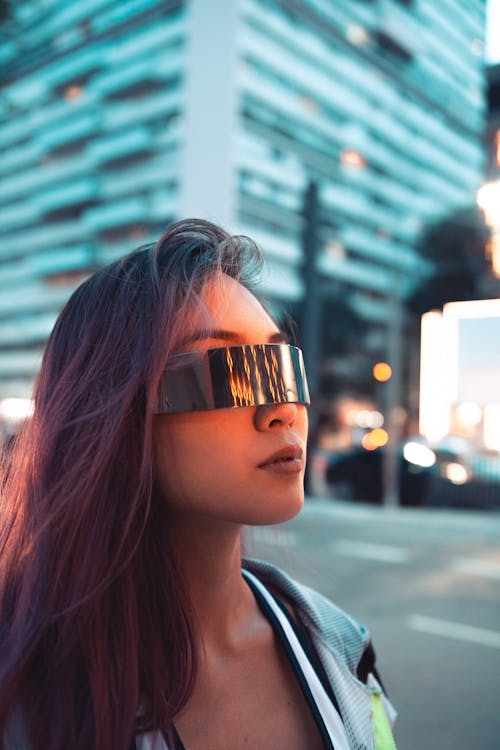 Free Woman Wearing Sunglasses Walking Near Building Stock Photo