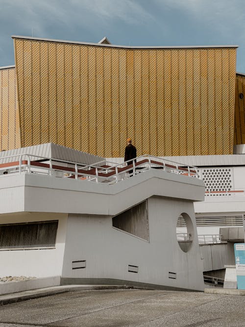 Tourist Standing on Stairs Looking at the Golden Facade of the Berliner Philharmonie