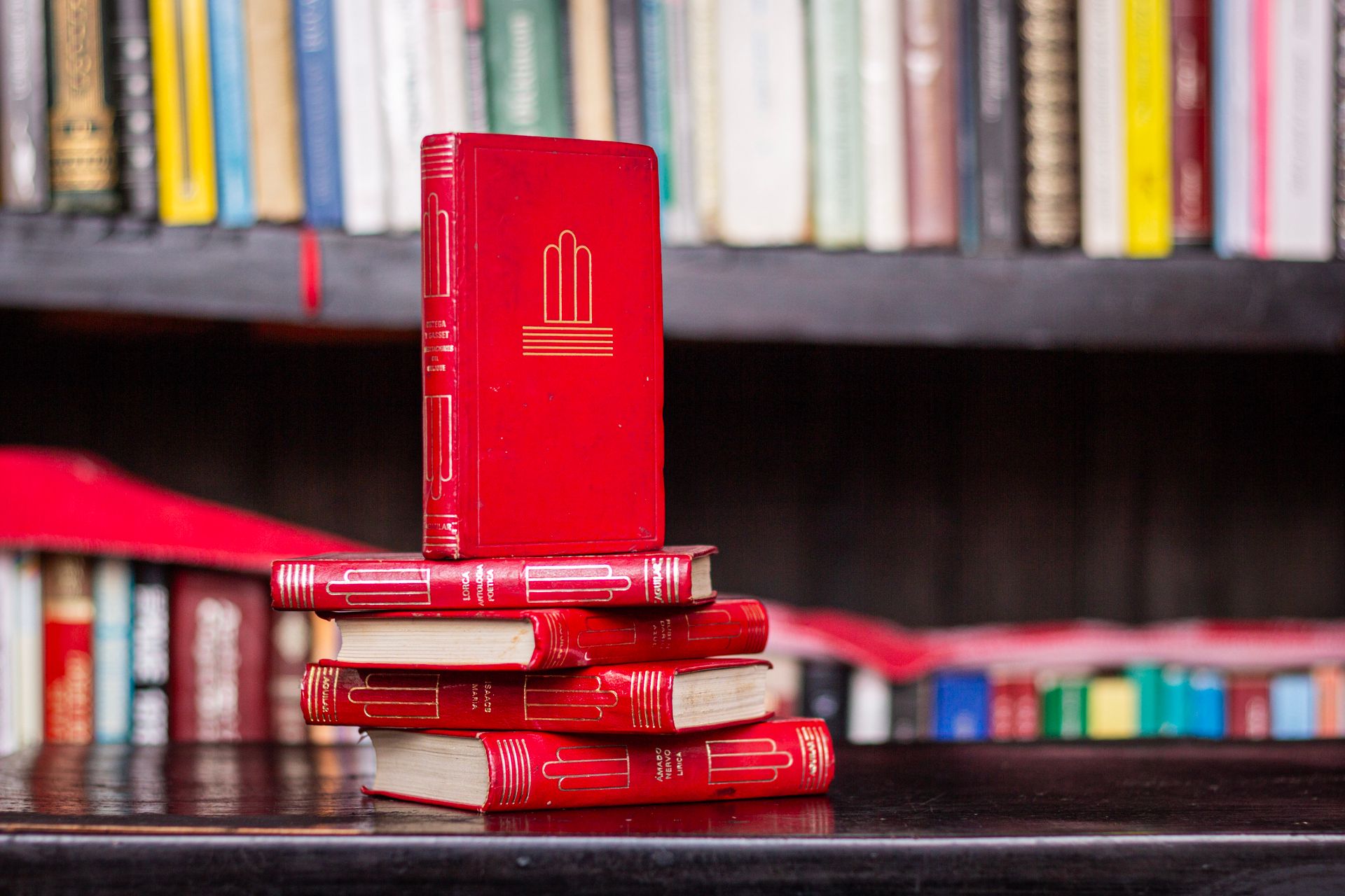 Red books stacked in a cozy library, perfect for literary concepts and education themes.