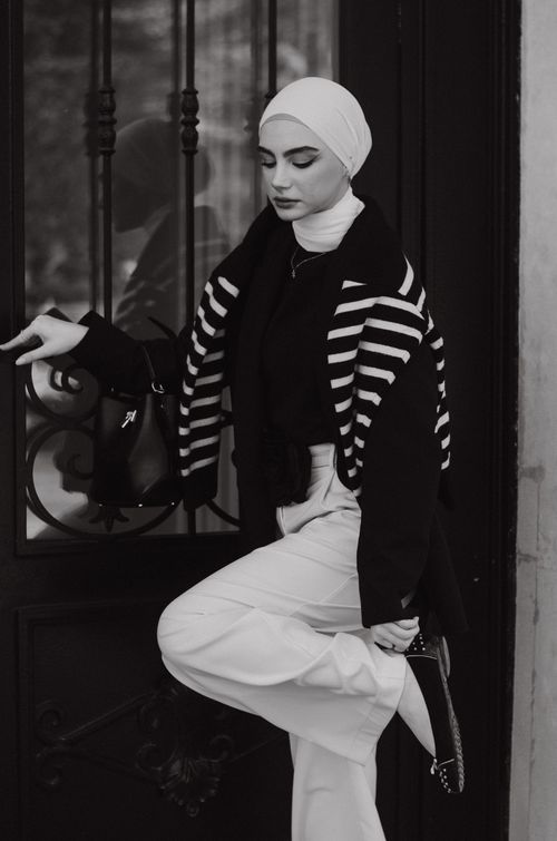 Free Black and white photo of a woman posing elegantly in the city. Stock Photo