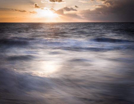 Serene sunset over the ocean waves at Borkum, capturing warm reflections and tranquil beauty.
