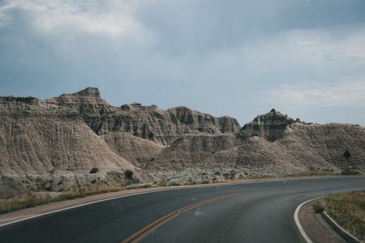 Curved highway through rugged rocky landscape under a clear summer sky, perfect for travel themes.