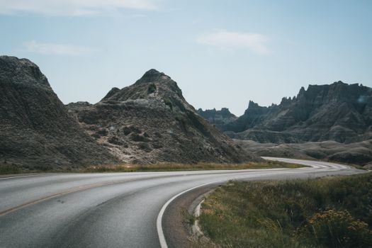 Curved highway winding through mountainous terrain under a clear sky.