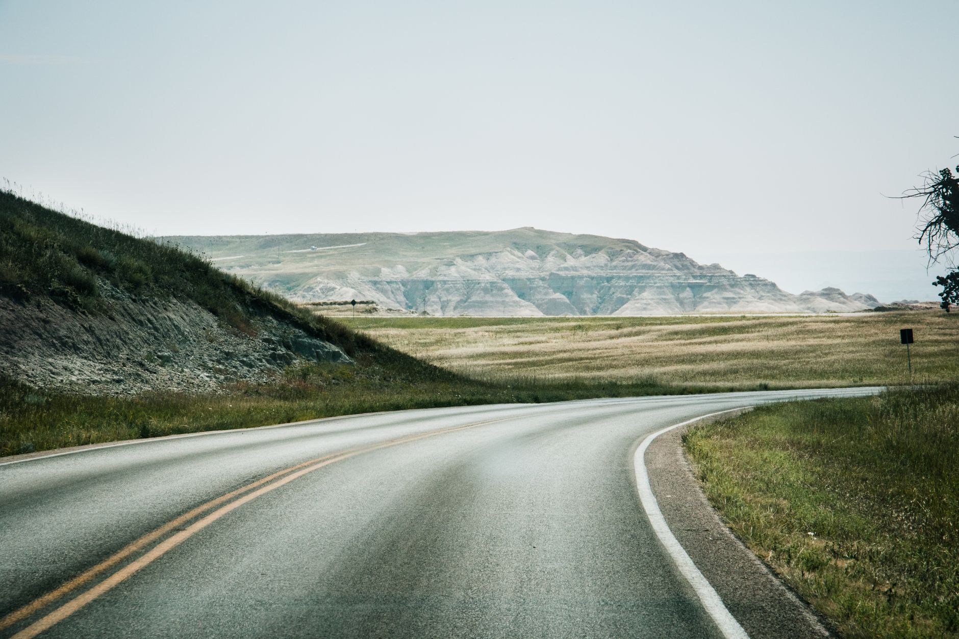 A picturesque highway winding through lush greenery and distant hills, perfect for travel enthusiasts.