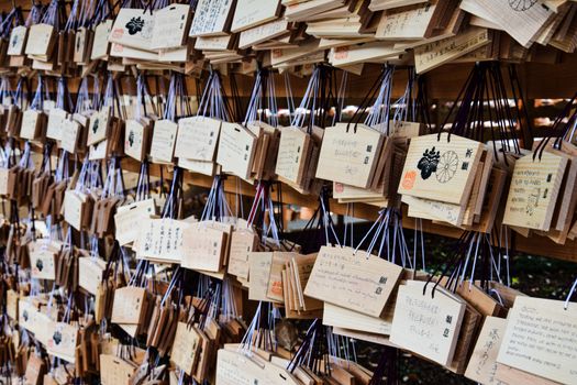 A wall of wooden prayer cards with writing on them