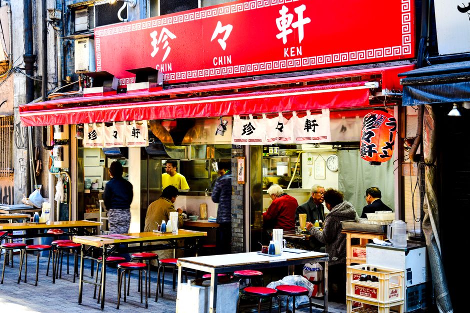日本の賑やかなストリートフードバーのシーンは活気ある都市の雰囲気を捉えています。