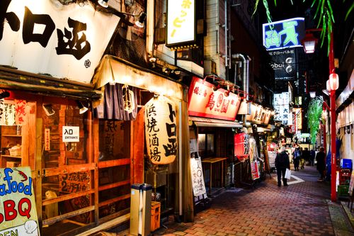 Free Explore the bustling atmosphere of Shinjuku's illuminated alley filled with cafes and shops during night in Tokyo. Stock Photo