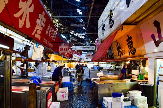 A vibrant scene of vendors and shoppers at Tsukiji fish market in Tokyo during nighttime.