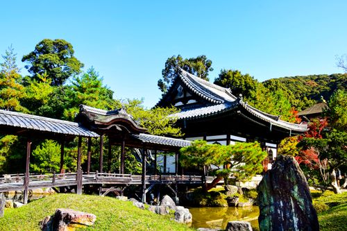 Free Scenic view of a traditional Japanese temple with lush gardens and a wooden bridge in Kyoto, Japan. Stock Photo