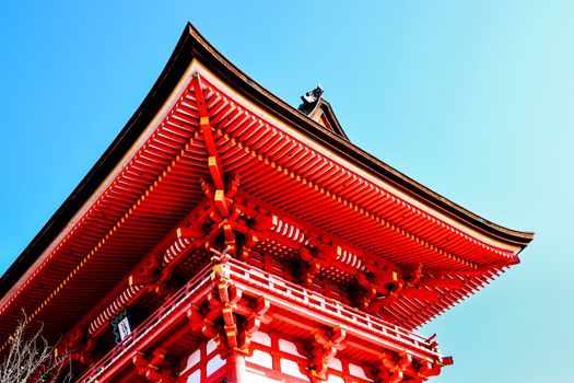 Bright red and white pagoda roof showcasing traditional Asian architectural style under blue sky.