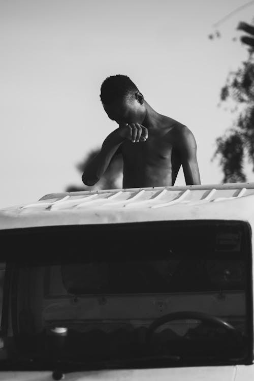 Topless Man behind Car in Black and White