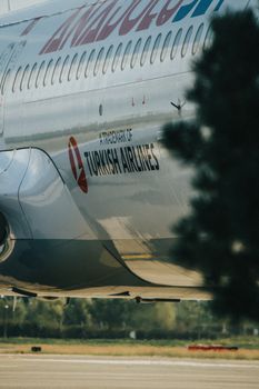 Detailed view of a Turkish Airlines airplane on an airport runway, focusing on the airline branding.